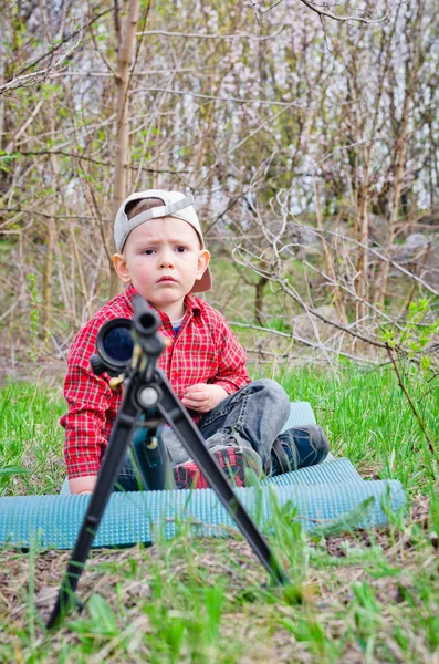 Worried young boy with a rifle — Stock Photo, Image