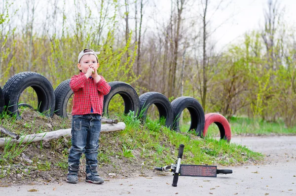 Junge spielt mit seinem Motorroller — Stockfoto
