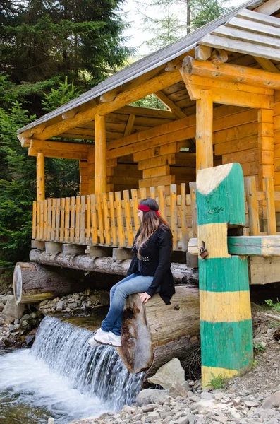 Frau sitzt und genießt einen hübschen Wasserfall — Stockfoto