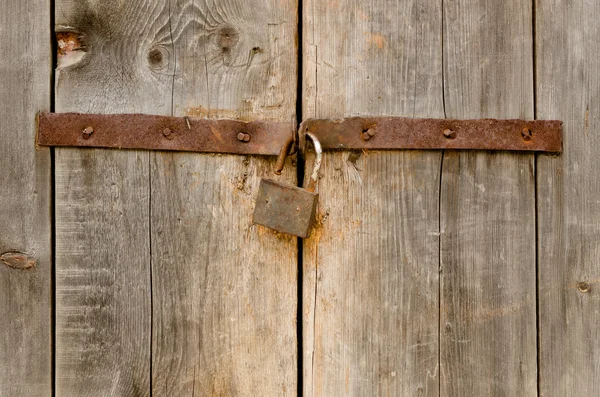 Old rusty padlock on a wooden door — Stock Photo, Image