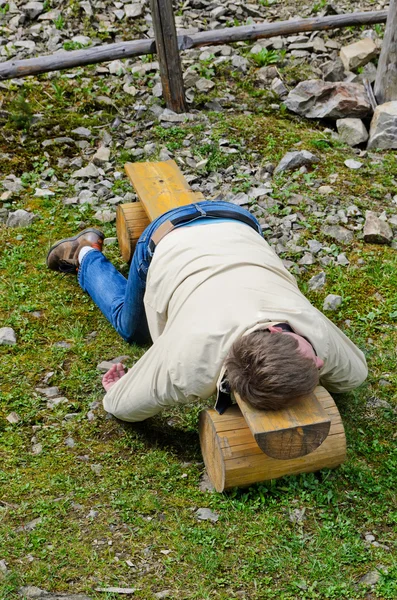 Ung blond man djupt sova på en bänk utomhus — Stockfoto