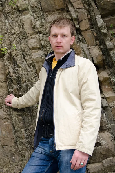 Attractive man posing against rocks — Stock Photo, Image