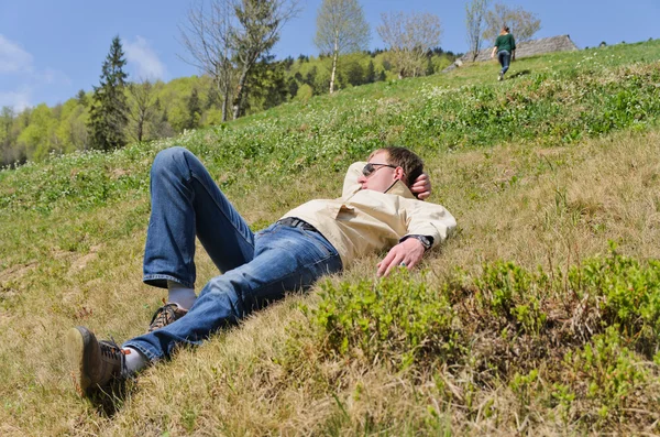 Muž leží na strmém svahu — Stock fotografie