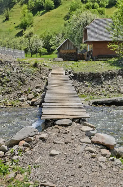 Puente rústico de madera sobre un arroyo — Foto de Stock