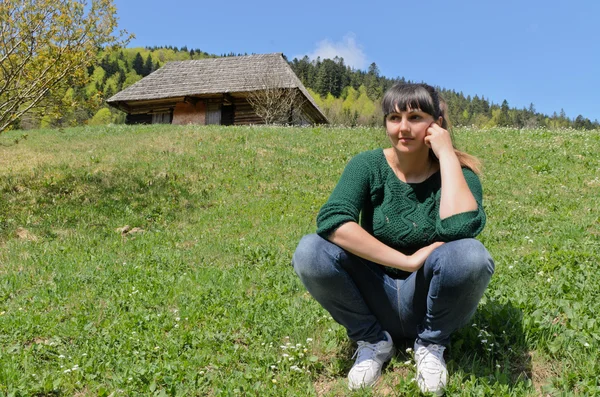 Atrakcyjna kobieta siedzi na zielony trawnik — Zdjęcie stockowe