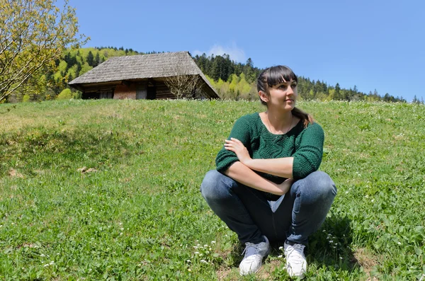 Donna seduta su un pendio verde di montagna — Foto Stock