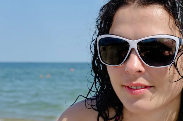 Frau mit Sonnenbrille posiert am Meer — Stockfoto