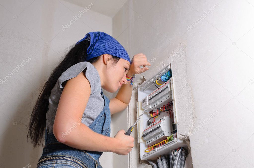 Female electrician with open fuse box