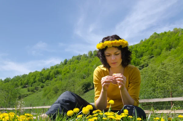 En ung kvinna att göra en krans av blommor — Stockfoto