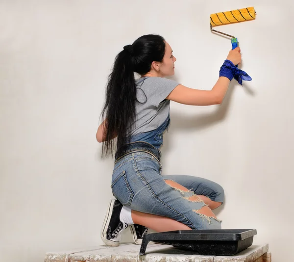 Jonge vrouw schilderij met een roller — Stockfoto