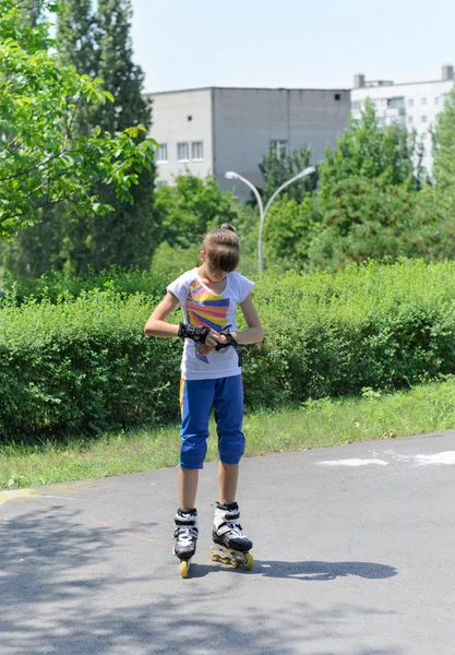 Patinador joven poniéndose protectores de palma — Foto de Stock