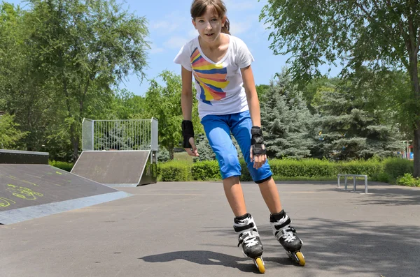 Giovane ragazza pattinaggio a rotelle in un parco skate — Foto Stock