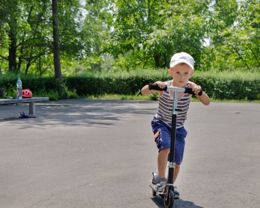 genç çocuk bir parkta bir scooter sürme