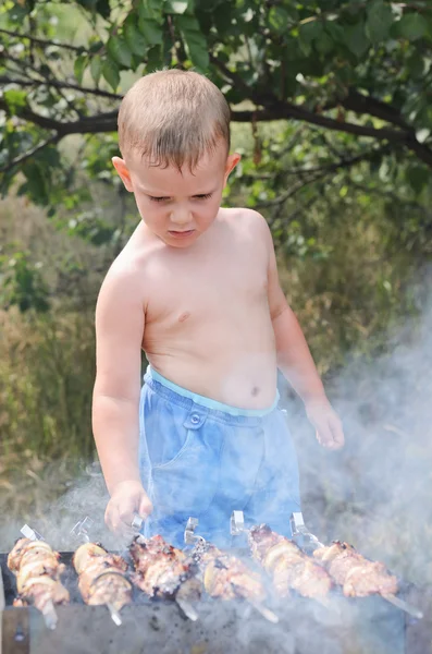 若い男の子、バーベキューで調理 — ストック写真