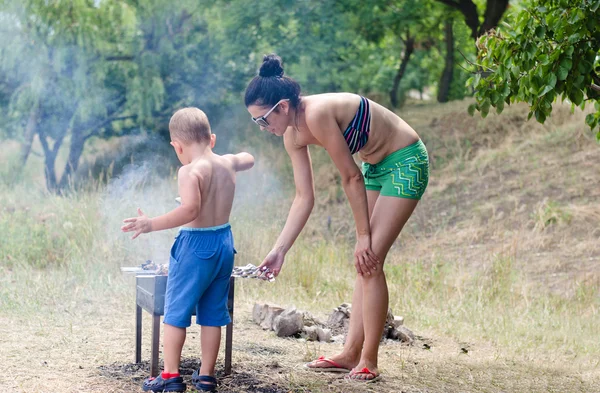 Jonge jongen te helpen bij de barbecue — Stockfoto