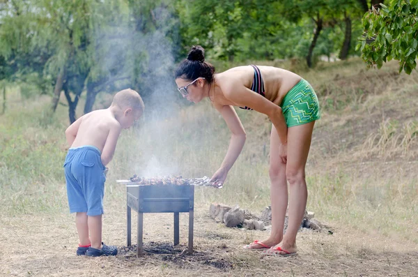 Jonge jongen te helpen bij de barbecue — Stockfoto