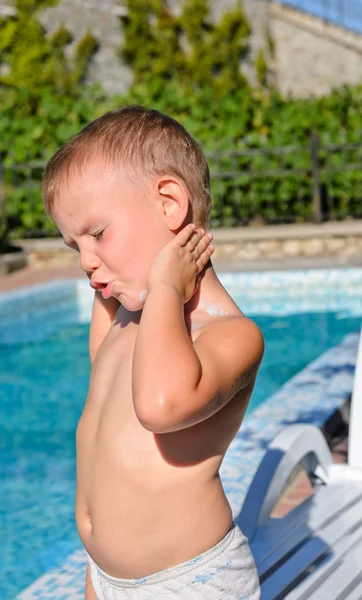 Young boy applying suntan lotion — Stock Photo, Image