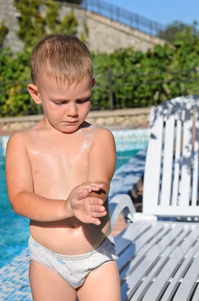 Försiktig liten pojke tillämpa solskyddsmedel — Stockfoto