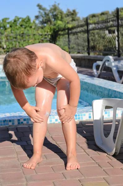 Youngster applying sunscreen to his skin — Stock Photo, Image