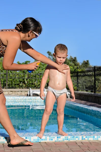 Moeder zonnecrème op haar zoon toe te passen — Stockfoto