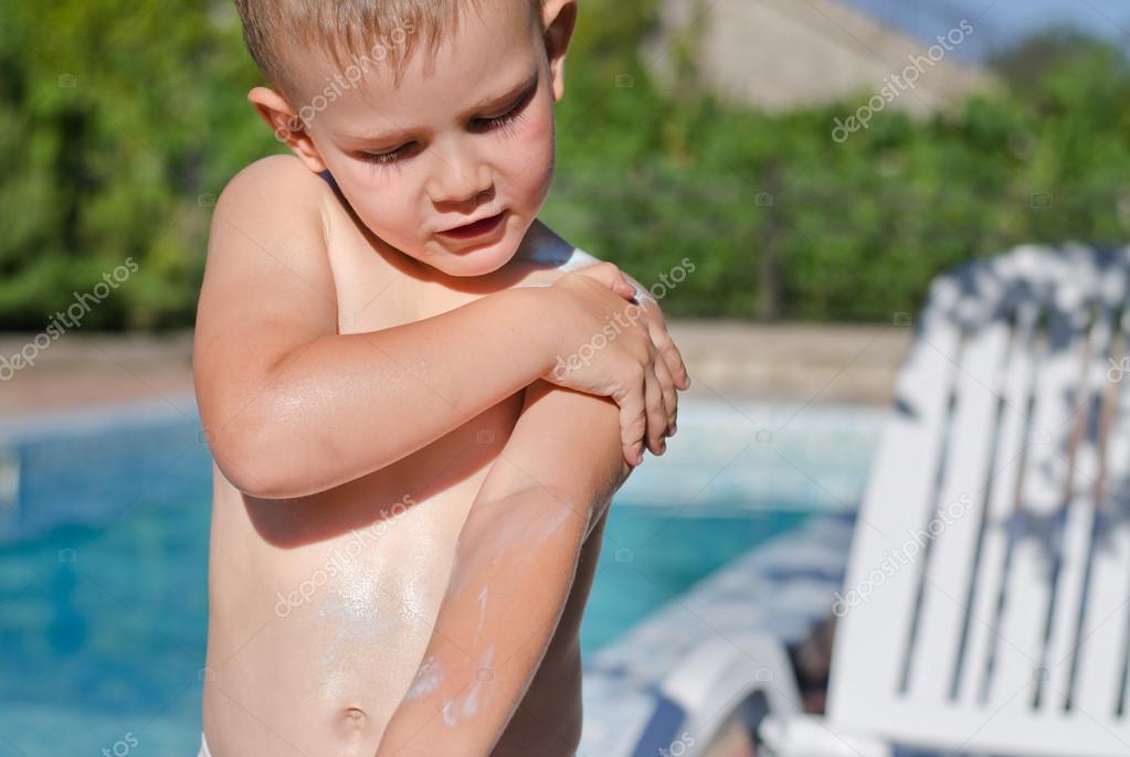 Young boy carefully applying sunscreen — Stock Photo © ampack 29958387