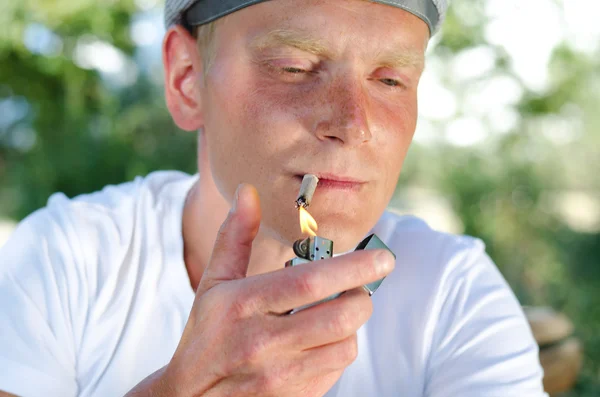 Портрет курильщика, закуривающего сигарету — стоковое фото