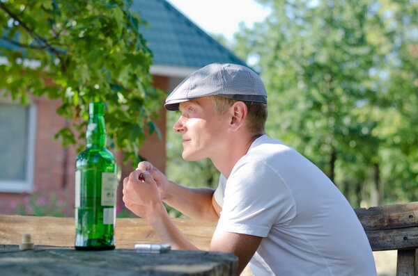 Young man enjoying a drink and cigarette