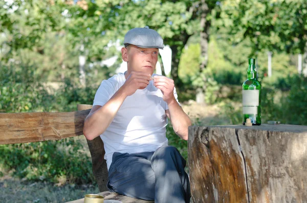 Man enjoying a bottle of wine and cigarette — Stock Photo, Image