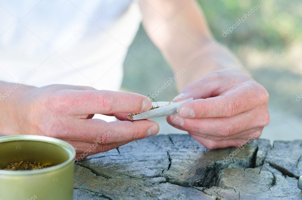 Male hands rolling a cigarette
