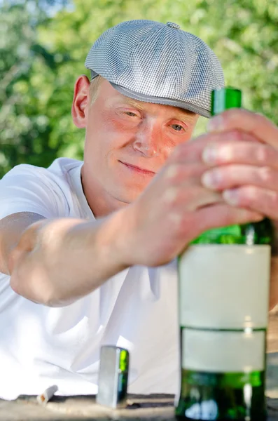 Drunk contemplating his bottle of booze — Stock Photo, Image