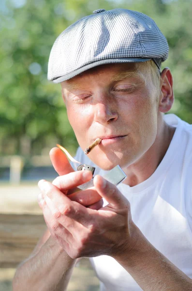 Homem acendendo um cigarro caseiro — Fotografia de Stock