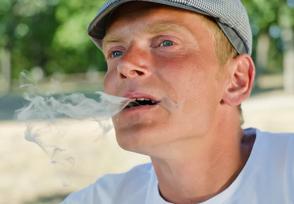 Homem a soprar fumo da boca — Fotografia de Stock