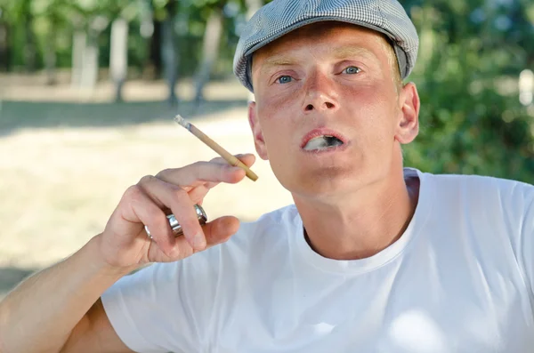 Молодой человек наслаждается сигаретой — стоковое фото