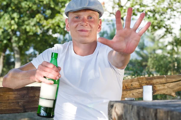 Betrunkener lächelt und verteidigt seine Flasche Alkohol — Stockfoto