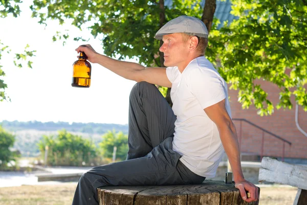 Человек, сидящий на улице, наслаждаясь напитком — стоковое фото