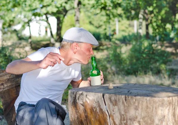 Un hombre tomando un trago de alcohol de una botella — Foto de Stock