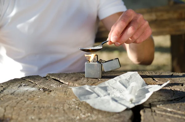 Addict heating cocaine in a spoon — Stock Photo, Image