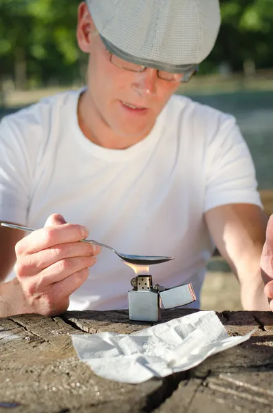 Hombre calentando drogas en una cuchara —  Fotos de Stock