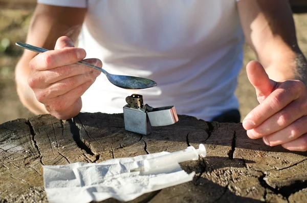 Hombre calentando crack cocaína en una cuchara —  Fotos de Stock