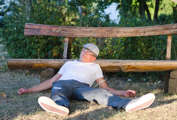 Drug addict lying in a park — Stock Photo, Image