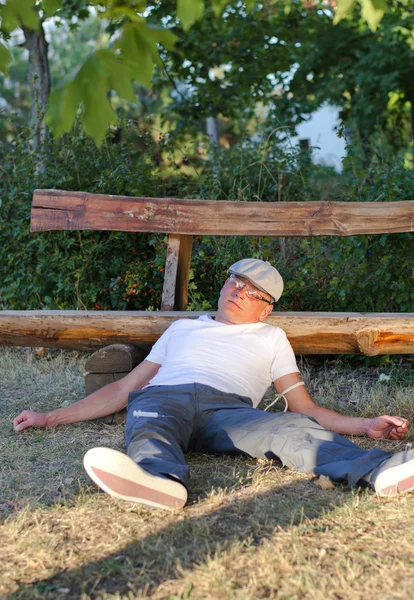 Drug addict lying in a park — Stock Photo, Image