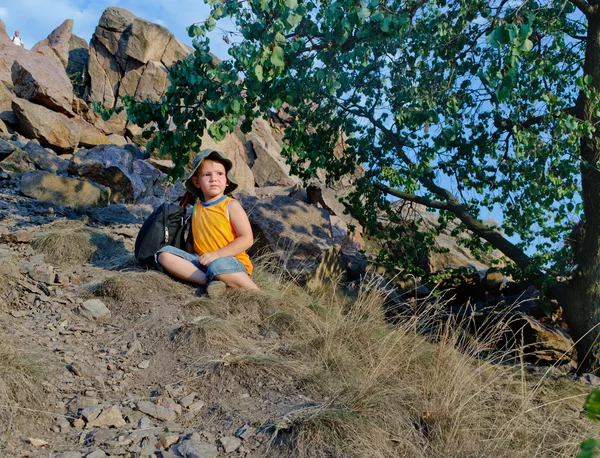 Little boy waiting patiently on a mountain slope — Stock Photo, Image