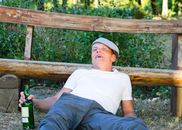 Alcoholic man drinking from a bottle of wine — Stock Photo, Image