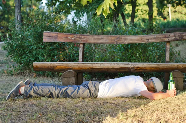 Ubriaco uomo addormentato fuori in un parco — Foto Stock