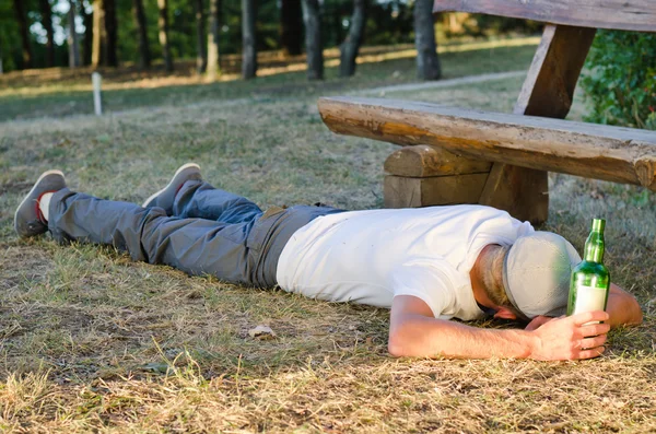 Drunk man sleeping it off in a park — Stock Photo, Image