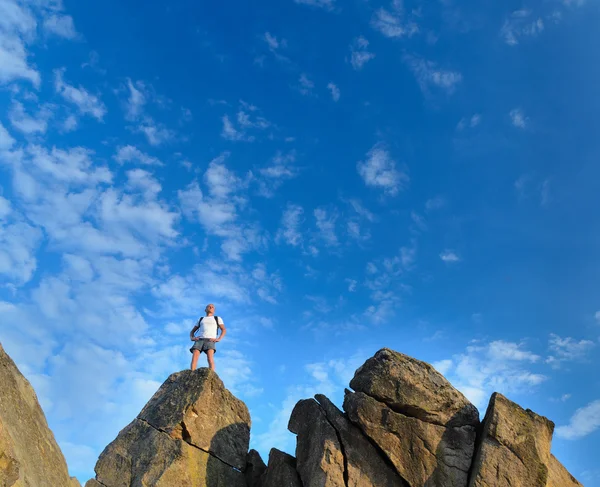 Hombre en la cima de un acantilado rocoso de montaña —  Fotos de Stock