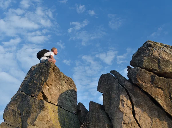 Backpacker uzak kayalık dağ tepe üzerinde — Stok fotoğraf