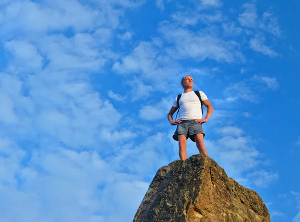 Решительный человек, стоящий на вершине горы — стоковое фото