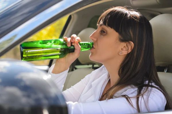 Alcoholic woman drinking a driving — Stock Photo, Image