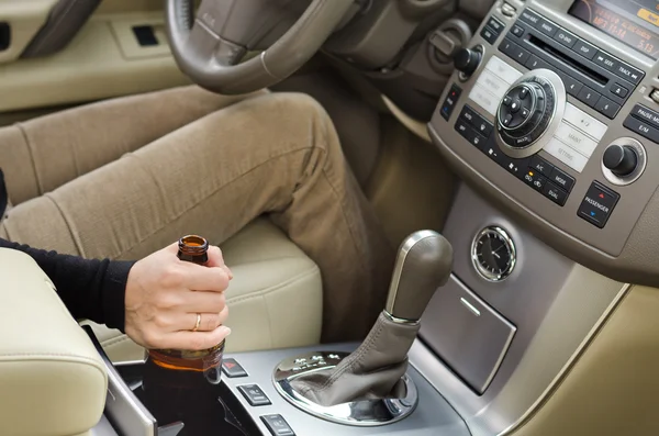 Vrouw alcoholische met een fles sterke drank in de auto — Stockfoto